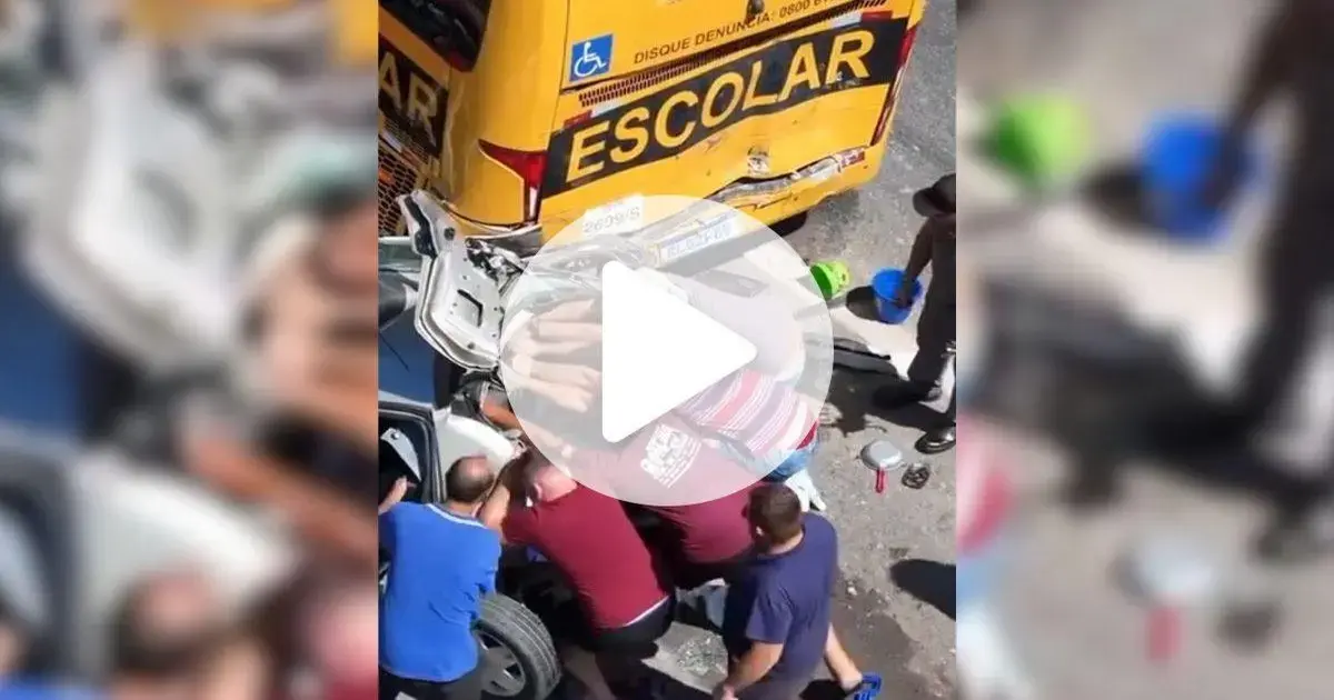 Acidente com ônibus escolar e carreta na BR-101 em Garopaba Pessoas ajudando no resgate de um veículo acidentado, com um ônibus escolar ao fundo.