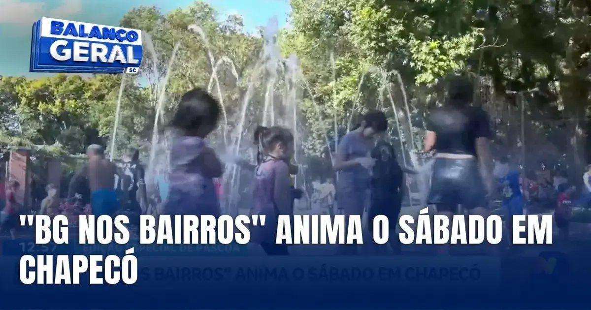 Crianças brincando em fonte com água, cercadas por árvores e pessoas no Ecoparque de Chapecó.