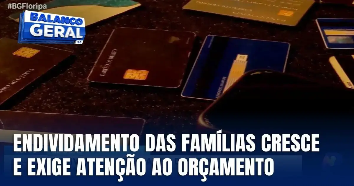 Cartões de crédito visíveis sobre uma superfície, com texto que menciona o aumento do endividamento das famílias e a necessidade de controle orçamentário.