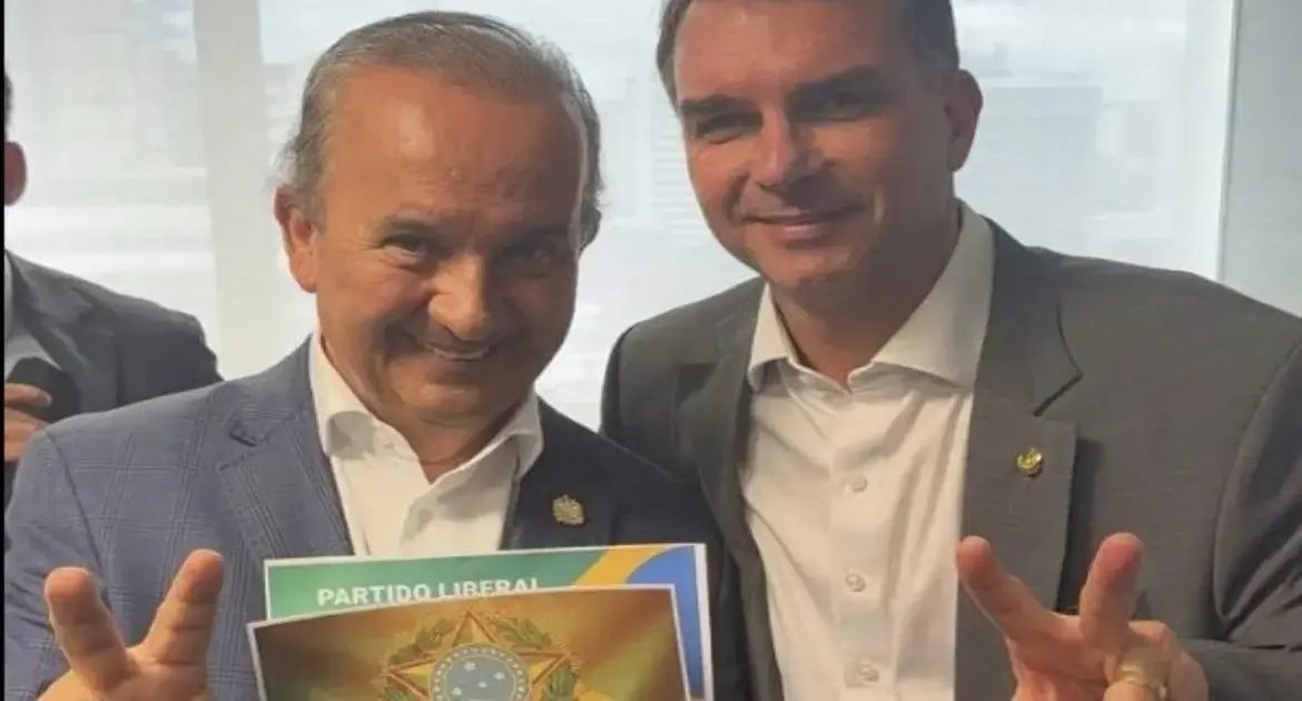 Duas pessoas sorriem enquanto seguram um folder com a frase 