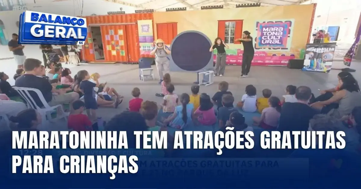 Pessoas assistindo a apresentações no Parque da Luz durante a Maratoninha, com mesas e cadeiras.