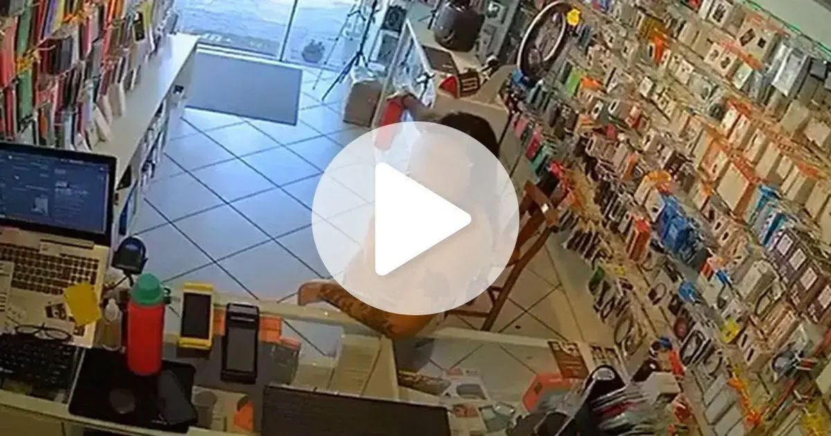 Mulher é indiciada por racismo em loja de Florianópolis Interior de loja com produtos em exibição, atendente sentado em uma cadeira com um computador na mesa.