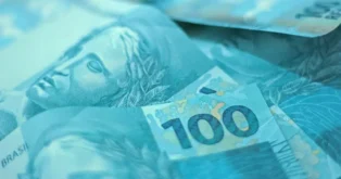 Notas de dinheiro em tons de azul, com destaque para a nota de R$ 100.