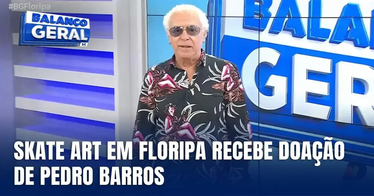 Apresentador em estúdio de TV, com camiseta colorida, anuncia doação para a exposição Skate Art em Florianópolis.