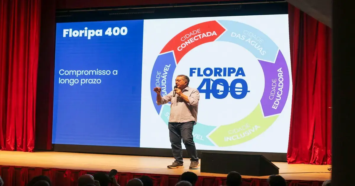Pessoa em pé apresentando um projeto chamado 