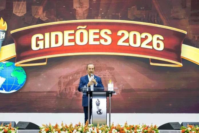 Homem em pé em um púlpito, falando para uma plateia, com fundo de tela exibindo "GIDEÕES 2026".