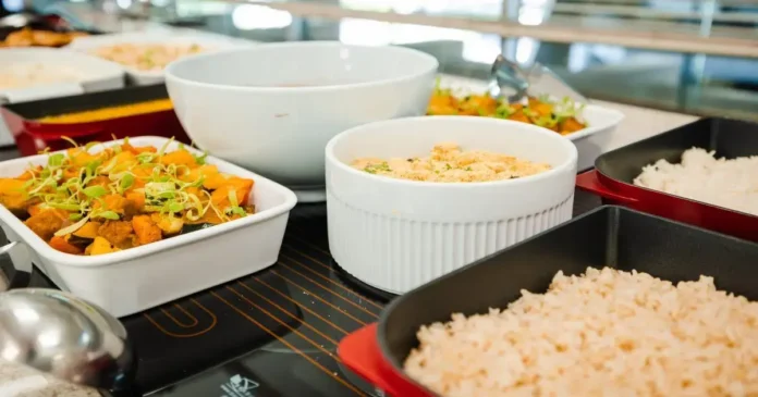 Pratos com comida variada, incluindo legumes, arroz e acompanhamento em recipientes de diferentes tipos.