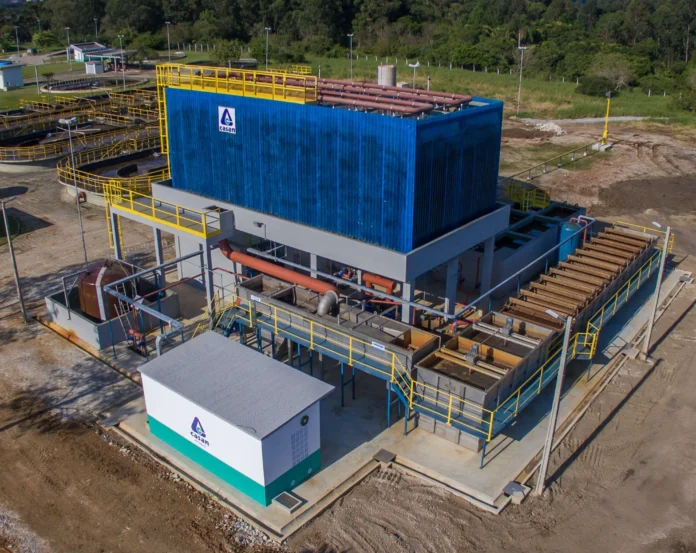 Estrutura de tratamento de água com tanques, tubulações e área de equipamento em um ambiente externo.