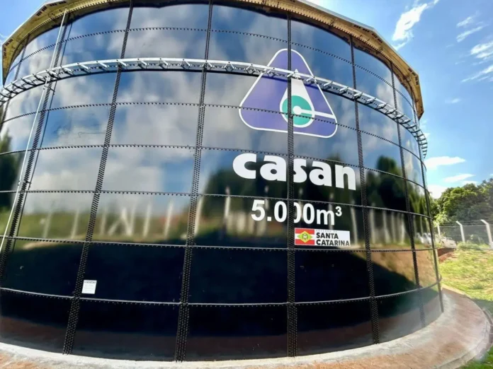 Tanque da CASAN com capacidade de 5.000 m³, localizado em Santa Catarina, com céu azul ao fundo.