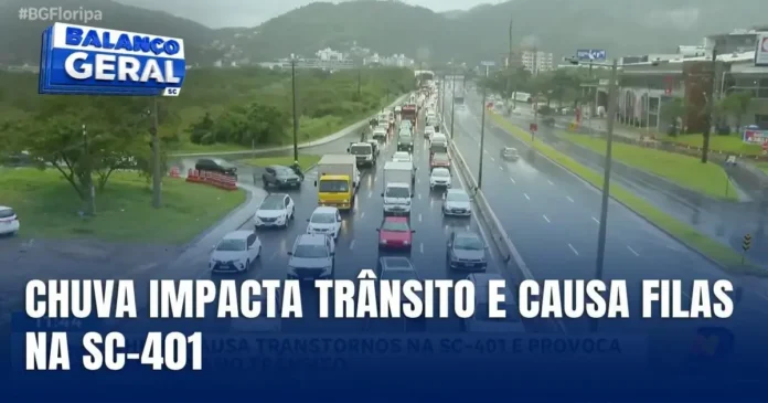 Trânsito congestionado na SC-401 durante a chuva, com veículos parados e lentidão visível na rodovia.