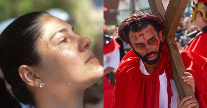 Mulher com lágrima visível olhando para cima e homem com aparência dramática segurando uma cruz.