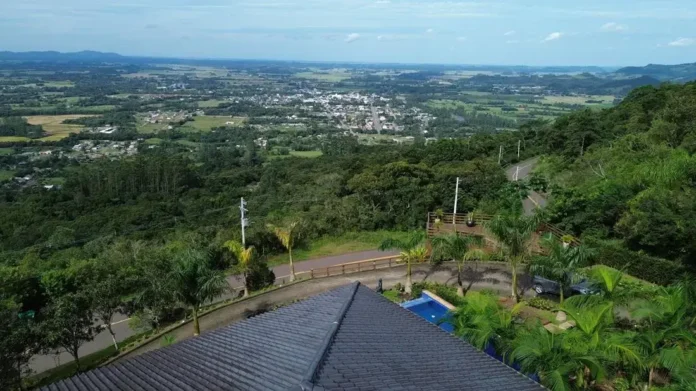 Vista panorâmica da Serra do Faxinal, com vegetação, estradas e propriedades ao fundo.