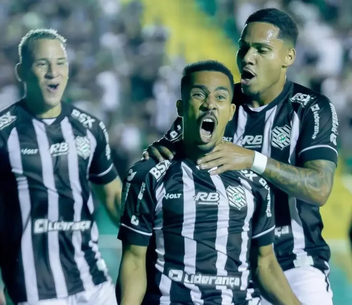 Jogadores comemorando um gol durante uma partida de futebol, com expressões de emoção e alegria.