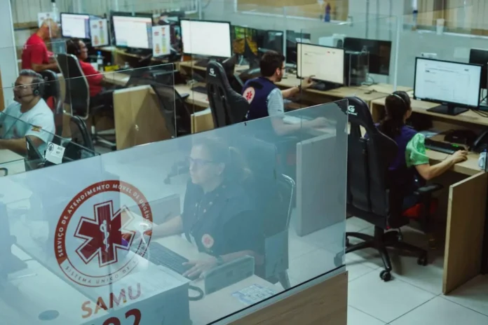 Ambiente de trabalho do Samu, com profissionais atendendo chamadas em estações de monitoramento e computadores.