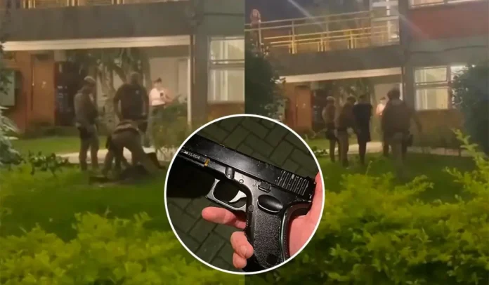 Agentes de segurança abordam um suspeito em área externa de um prédio, com um simulacro de arma visível.