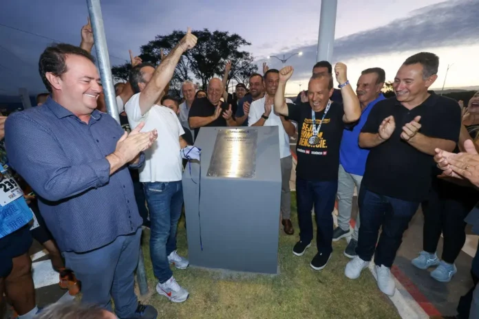 Grupo de pessoas celebrando a inauguração de uma placa em uma cerimônia pública.