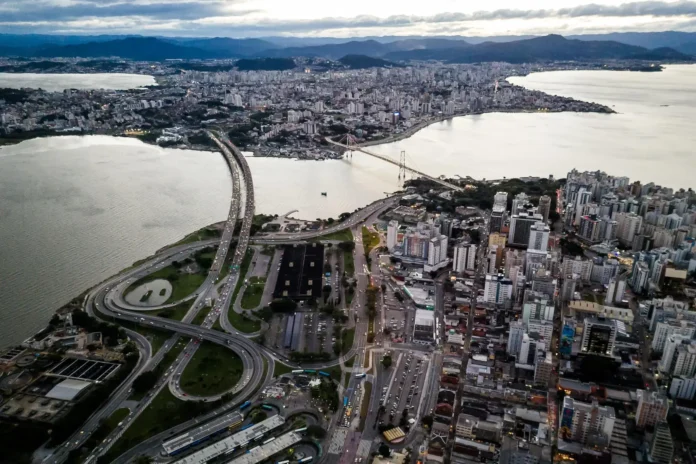 Vista aérea de uma cidade com prédios, estradas e uma ponte sobre um rio.