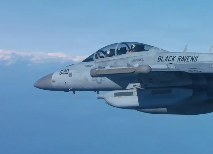 Avião militar de combate em voo, com a presença de tripulantes visíveis na cabine.