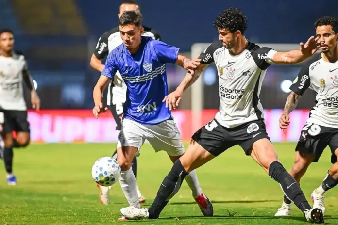 Dois jogadores disputam a posse da bola em campo durante uma partida de futebol.