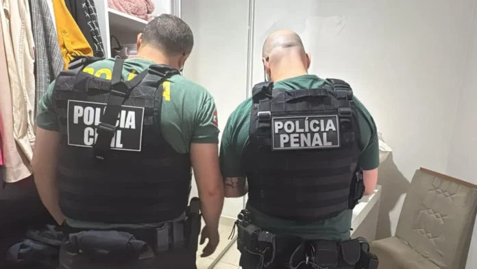 Dois agentes em uniformes táticos, um com "Polícia Civil" e outro com "Polícia Penal", dentro de um espaço fechado.