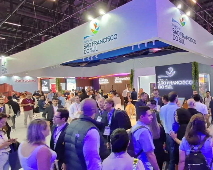 Estande do Porto de São Francisco do Sul em evento com diversas pessoas interagindo e conhecendo o local.