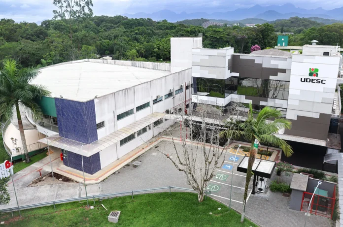 Prédio da Udesc em meio a áreas verdes, com calçadas e sinalizações para deficientes.