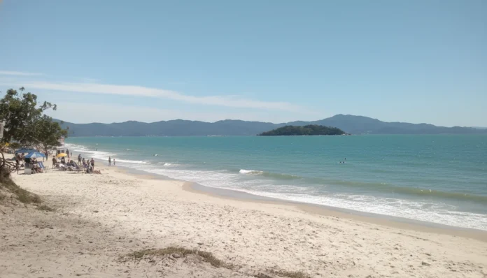 Praia de Canasvieiras com águas cristalinas e bandeiras de balneabilidade