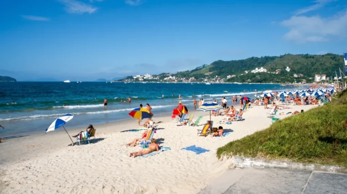 Praia de Jurerê com águas cristalinas e visitantes aproveitando o sol